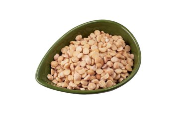 Yeşil bir tabak içindeki çiğ sarı bezelyeler beyaz arka planda izole edilmiş..