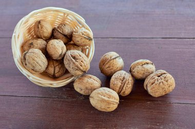 Fındık kabuğu. Hasır tabakta ceviz. Tahta masa.