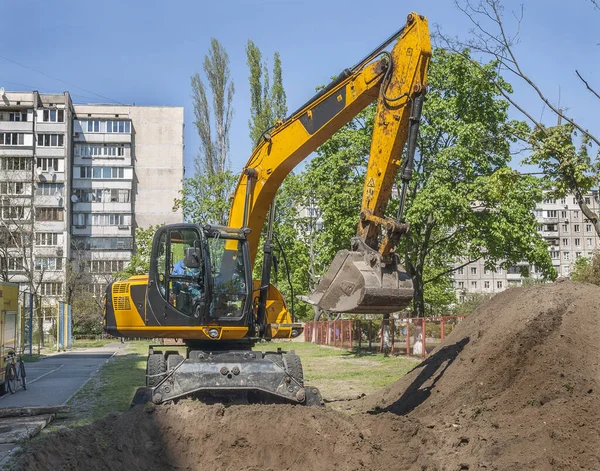 Kazıcı konut binaları arasında arazi kazıyor