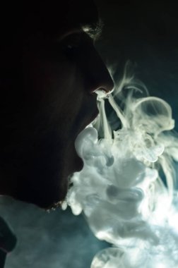 Çapkın gençler. Genç yakışıklı adam, Vape Bar 'da elektronik sigara içiyor. Kötü alışkanlık sağlığa zararlıdır. Buhar etkinliği.