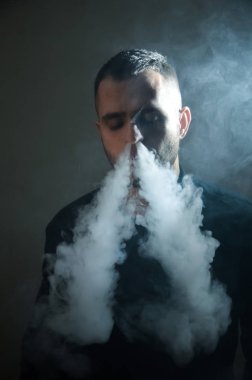 Çapkın gençler. Genç yakışıklı adam, Vape Bar 'da elektronik sigara içiyor. Kötü alışkanlık sağlığa zararlıdır. Buhar etkinliği.