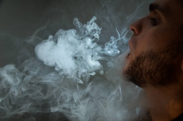 Подростки-вампиры. Молодой красавчик курит электронные сигареты в баре. Плохая привычка, вредная для здоровья. Падающая активность
.