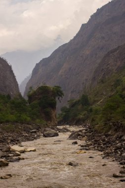 Manaslu bölgesindeki Himalayalar 'ın dağ zirveleri arasında akan hızlı bir dağ nehri.