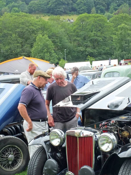 Homens mais velhos na conversa sobre um carro vintage no parque publie em hebden ponte fim de semana vintage anual — Fotografia de Stock