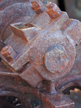 close up of an axle bolts and wheel on old rusted abandoned industrial machinery