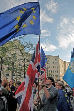 a man waving flags in a crowd at the leeds for europe anti brexit demonstration