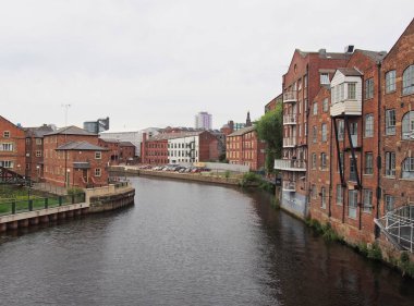 riverside view of the calls landing area of leeds with waterfront apartments and buildings reflected in the river aire