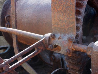 close up of rusted cogs bolts and gears on an old broken industrial winching machine