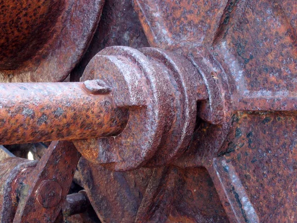 Close up of an axle and wheel on old rusted abandoned industrial machinery — 스톡 사진