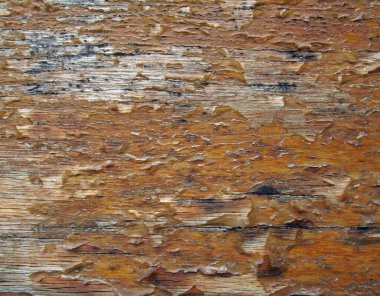 close up of an old brown wooden panel with peeling flaking varnish