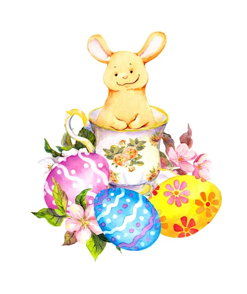 花のティーカップは、着色された卵のかわいいイースターのウサギ。水彩 — ストック写真