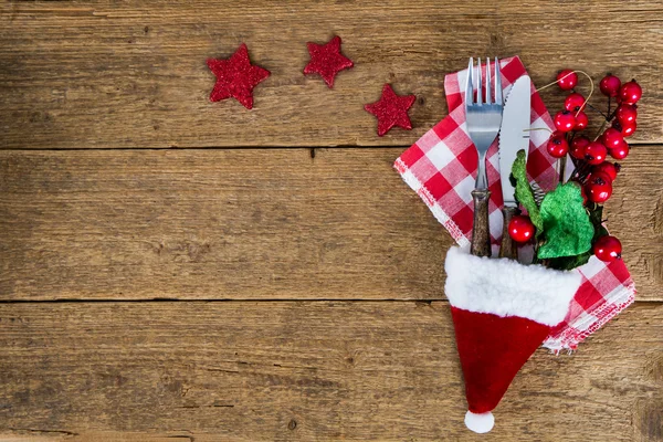 The cutlery on the woodwn table in santa hat — Stock Photo, Image