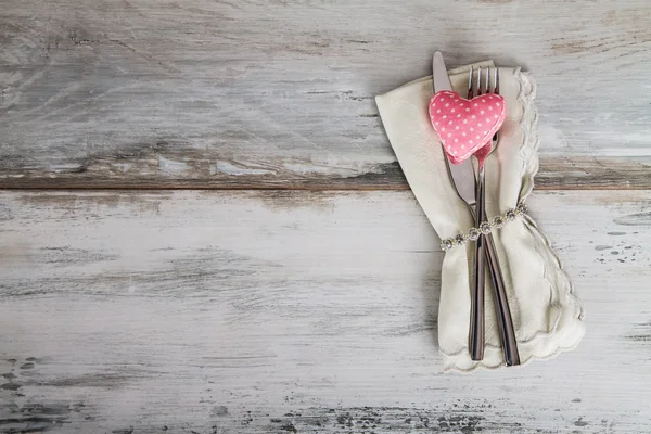 Posate sul tavolo e cuore rosa — Foto Stock