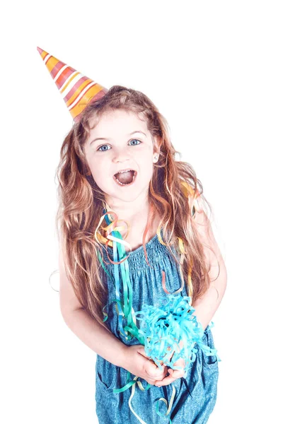 Petite fille souriante avec sifflet et chapeau de cône — Photo