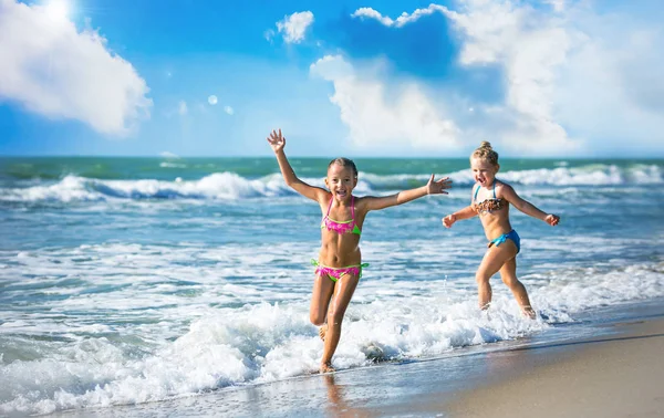 Chicas felices corren en la orilla del mar Imágenes de stock libres de derechos
