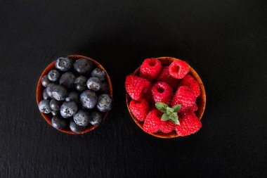 yaban mersini ve ahududu ile taze nane yaprakları siyah arduvaz kurulu. 