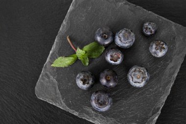  yaban mersini ile taze nane yaprakları siyah arduvaz kurulu. 