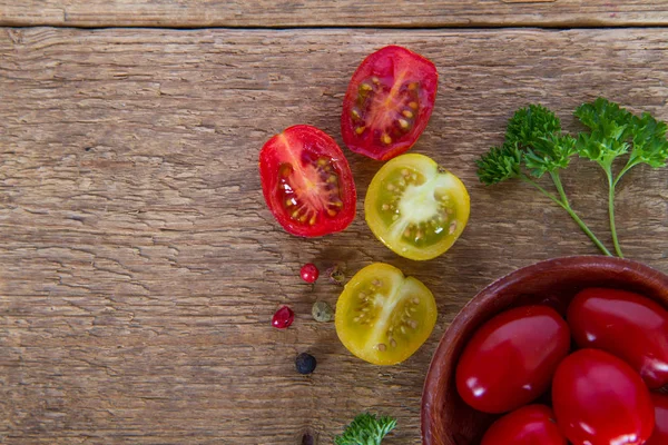 Red and yellow tomatoes with parsley in wooden dish — Stock Photo, Image