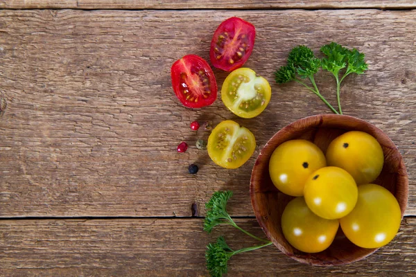 Red and yellow tomatoes with parsley on wooden background — Stock Photo, Image