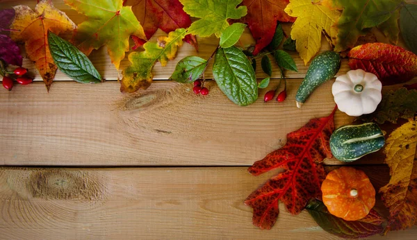 Herbstblätter und Kürbisse auf Holzgrund — Stockfoto