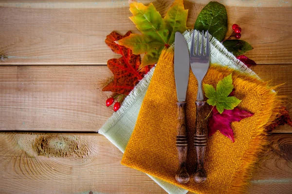 Besteck auf Holz mit Herbstblättern Stockfoto