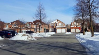 Kış mevsiminde yoğun giysili yerleşim yerlerinde kaldırımda yaya yürüyüşleri. Adam kar caddesi boyunca ceketiyle gün içinde soğuk havada yürüyor..