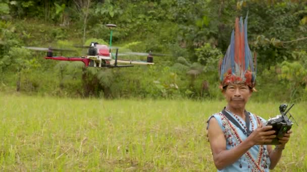 Viejo hombre indígena sonríe mientras juega con un dron — Vídeo de stock