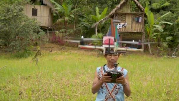 Alter indigener mann spielt draußen in seinem dorf mit einer drohne — Stockvideo