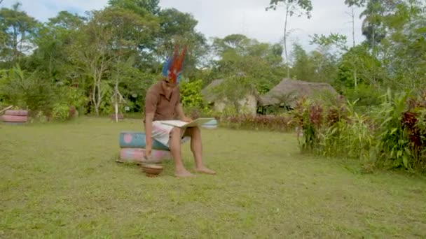 Giovane uomo indigeno sta lavorando sul suo computer portatile fuori nel suo villaggio natale — Video Stock