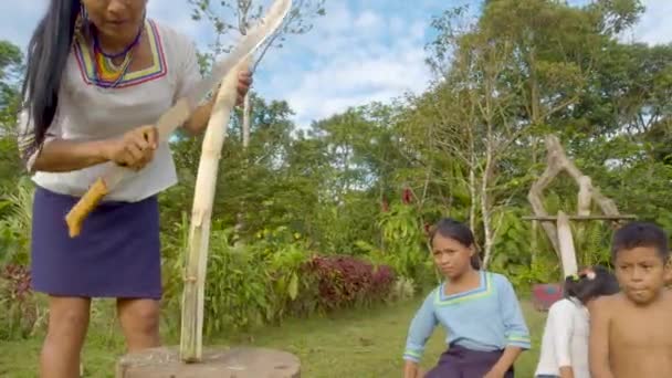 Los niños están viendo a una mujer cortar una caña de azúcar con un machete — Vídeo de stock