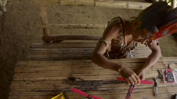 O homem indígena está construindo um drone — Vídeo de Stock