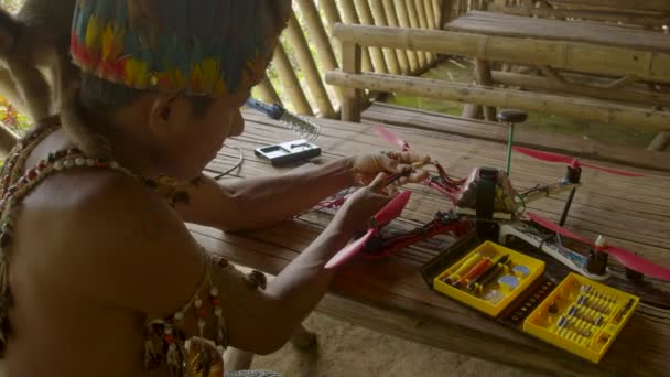 L'uomo indigeno sta collegando fili a un drone con scimmia sulla spalla — Video Stock