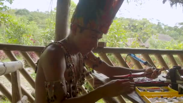 A fiatal bennszülött ember drótokat köt össze az önmaga által épített drónnal. — Stock videók