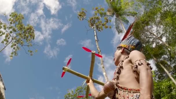 O homem indígena está a verificar se um dispositivo voador que ele construiu pode voar. — Vídeo de Stock