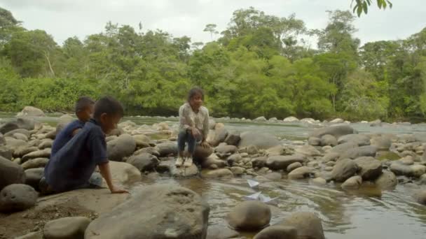 Niños indígenas juegan con barcos de papel — Vídeos de Stock