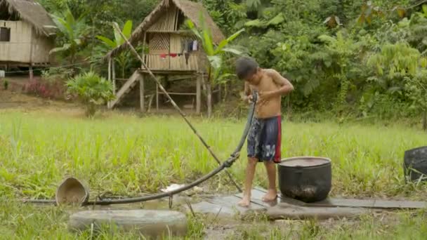 Dva mladí domorodí chlapci se čistí od bahna — Stock video