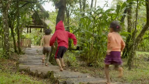 Pueblos indígenas corriendo descalzos en un camino forestal para llegar a su aldea — Vídeo de stock