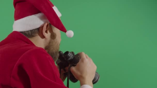 Erwachsener Mann Weihnachtsmann schaut durch Fernglas — Stockvideo
