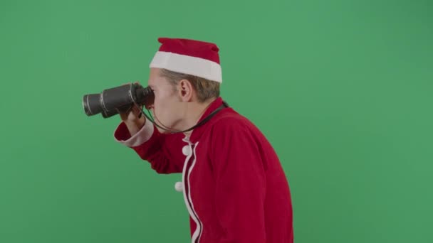 Dospělý muž Santa Claus hledá ačkoli binokuláry — Stock video