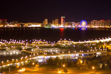 Gece, uzakta büyük bir dönme dolap, nehir ve Rusya 'nın Kazan şehrinin ön tarafındaki setle aydınlandı.