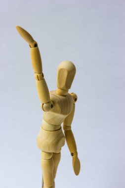 Tahta figür, beyaz üzerine izole edilmiş. Manken selamlamak ya da veda etmek için elini kaldırdı.