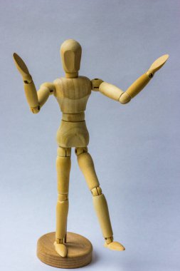 Tahta figür, beyaz üzerine izole edilmiş. Manken ellerini beyaz arka planda karmaşa içinde açtı..