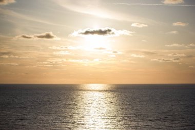 Suyun üzerinde ufuk çizgisi. Sakin bir denizde güzel bir gün batımı. Huzurlu deniz manzarası.