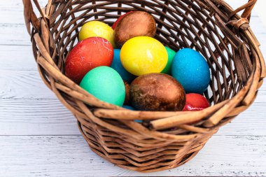 Bir sürü sade Paskalya yumurtası. Beyaz ahşap arka planda Mutlu Paskalyalar tatili için ev yapımı yumurtalar. Hasır bir sepette haşlanmış yumurta..