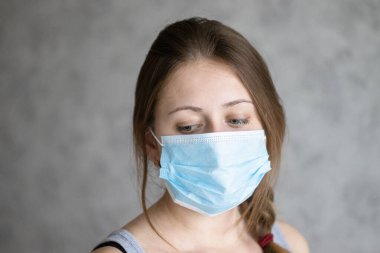 Hava kirliliği, koronavirüs ya da grip yüzünden maske takan güzel bir genç kadın. Yüz koruması için tıbbi maskeli bir kız. Virüs salgınını ya da salgınını önleme yöntemi.