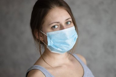 Hava kirliliği, koronavirüs ya da grip yüzünden maske takan güzel bir genç kadın. Yüz koruması için tıbbi maskeli bir kız. Virüs salgınını ya da salgınını önleme yöntemi.