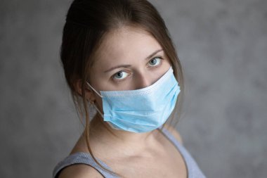 Hava kirliliği, koronavirüs ya da grip yüzünden maske takan güzel bir genç kadın. Yüz koruması için tıbbi maskeli bir kız. Virüs salgınını ya da salgınını önleme yöntemi