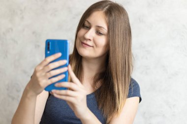 Güzel bir kadın evde selfie çekiyor. Arkadaşlarıyla ya da akrabalarıyla cep telefonuyla konuşan tatlı bir kız. Video görüşmesi için akıllı telefonu kullanan mutlu bir kadın..