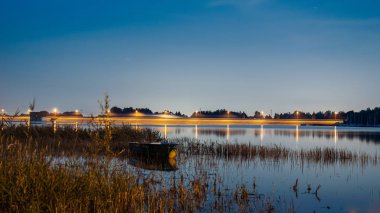 Geceleri gölde yanan bir kayık.