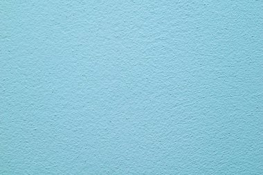 Görünür alçı dokusuyla maviye boyanmış duvar.